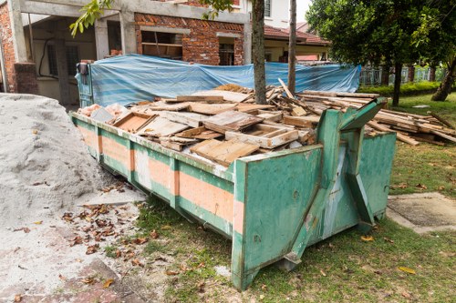 Rubbish collection worker using safety equipment near waste bins